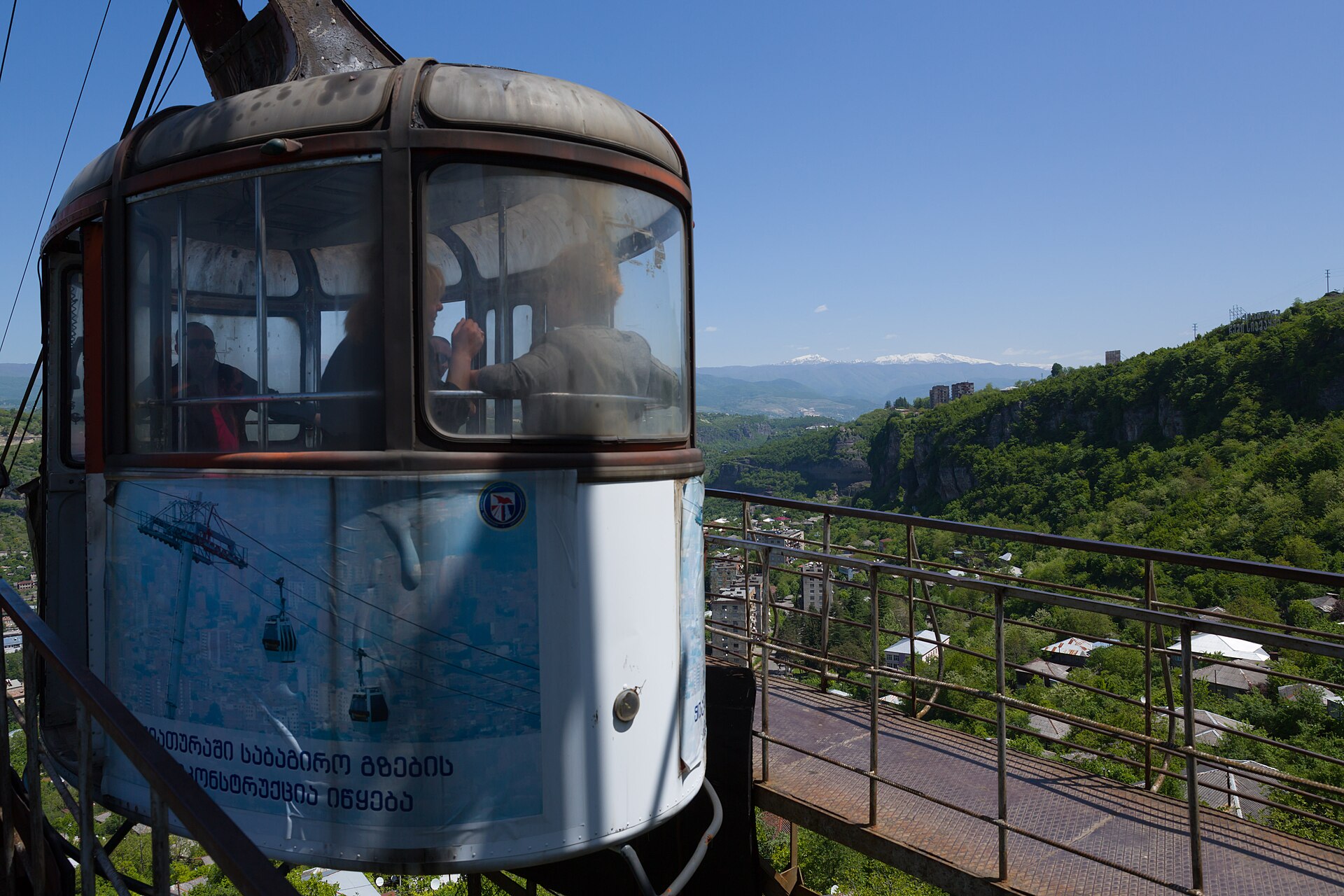Cable-car cabin at a hillside station overlooking Chiatura's green valley and distant mountains