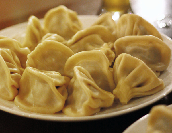 Golden khinkali dumplings with low, folded tops on a plate