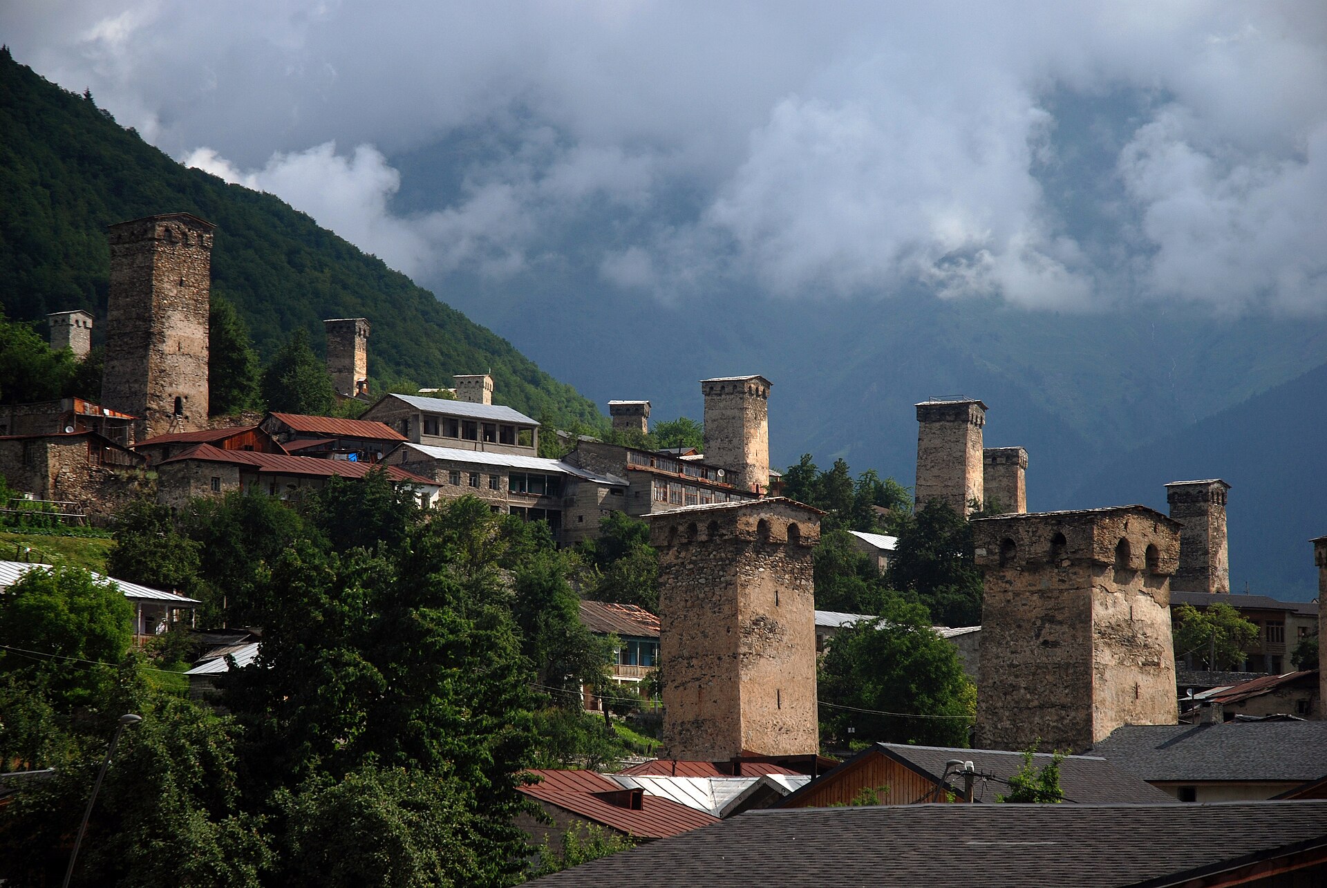 Svan defensive towers and houses in Mestia beneath cloudy mountains
