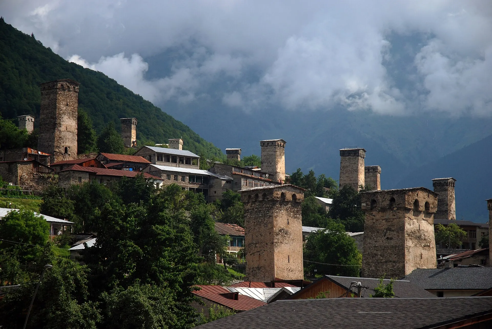 Svan defensive towers and houses in Mestia beneath cloudy mountains
