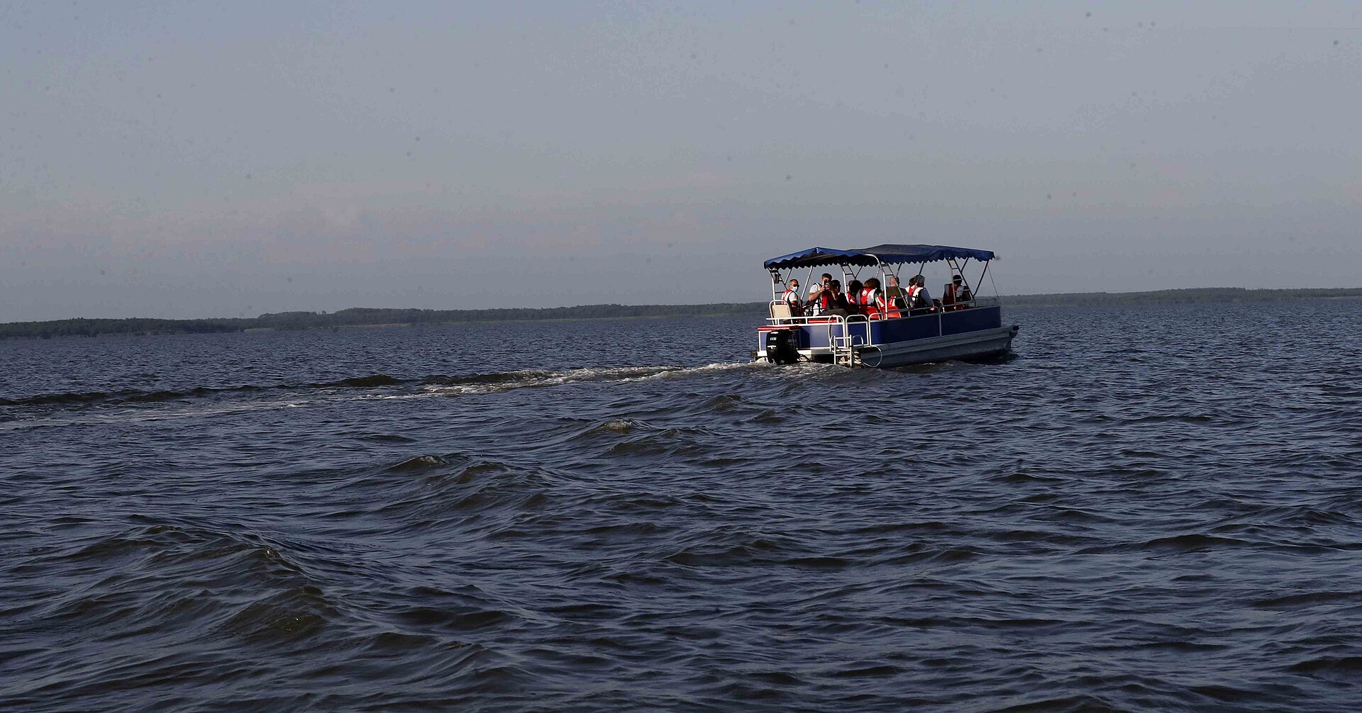 Covered tourist boat carrying visitors across Lake Paliastomi