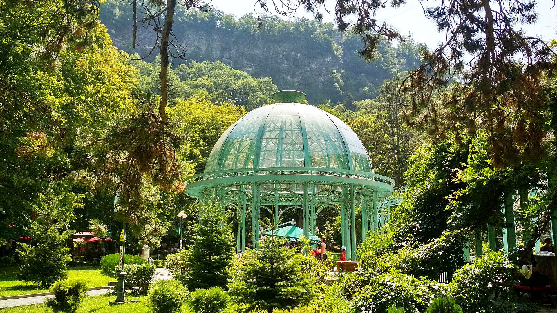 Green glass mineral-water pavilion among trees in Borjomi Central Park