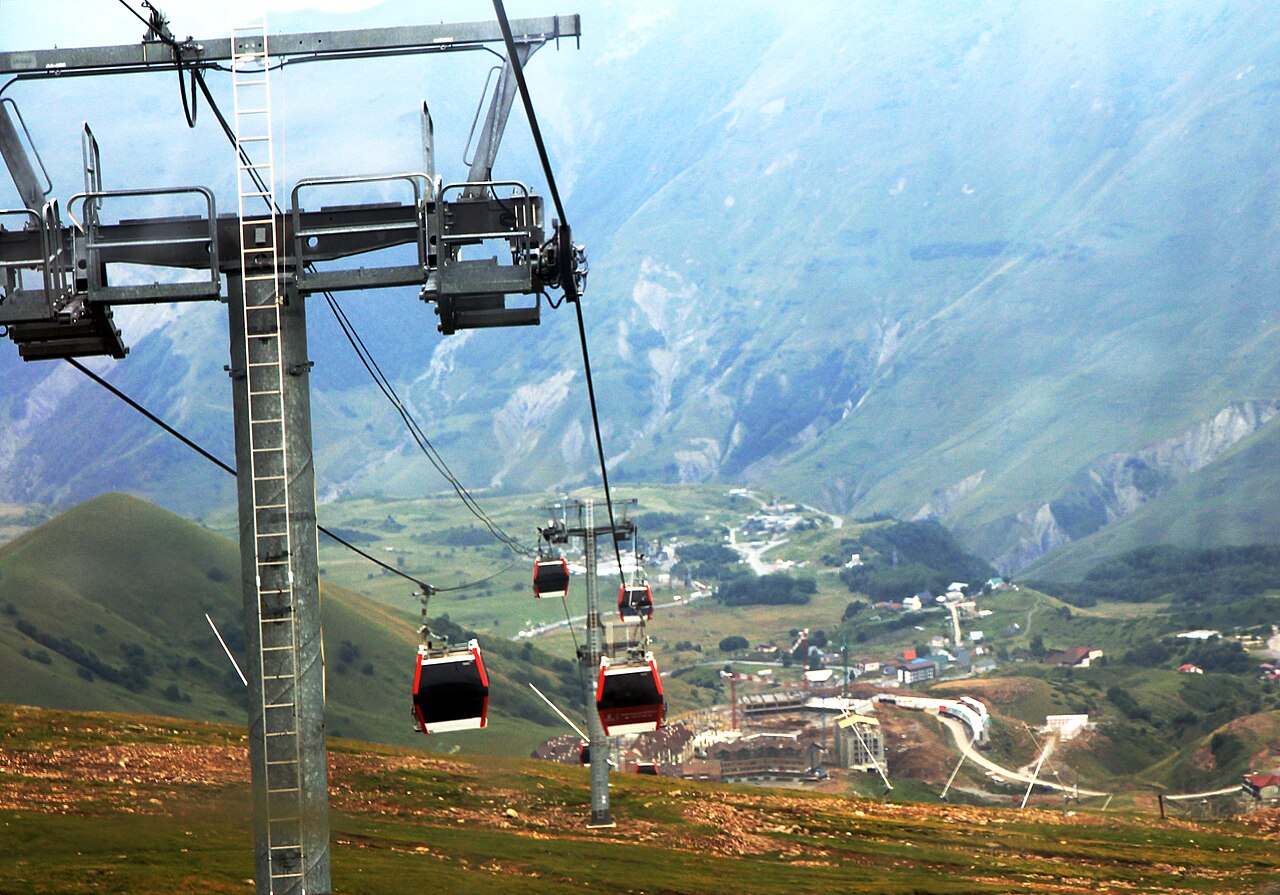 Cable-car cabins crossing the green mountain slopes between Gudauri and Kobi