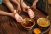 indian doctors doing traditional ayurvedic oil foot massage